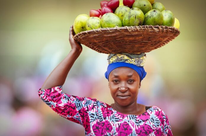 Rwandan woman with fruits for sale | Getty Images